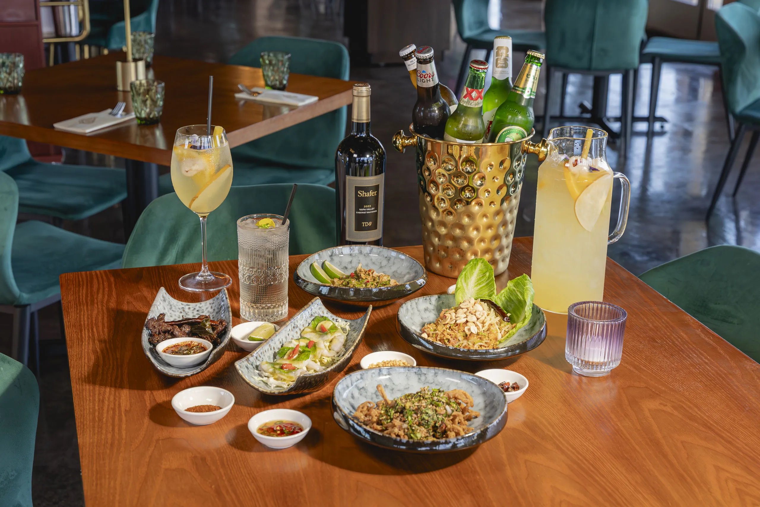Shared plates and cocktails on a table at Amata Modern Thai